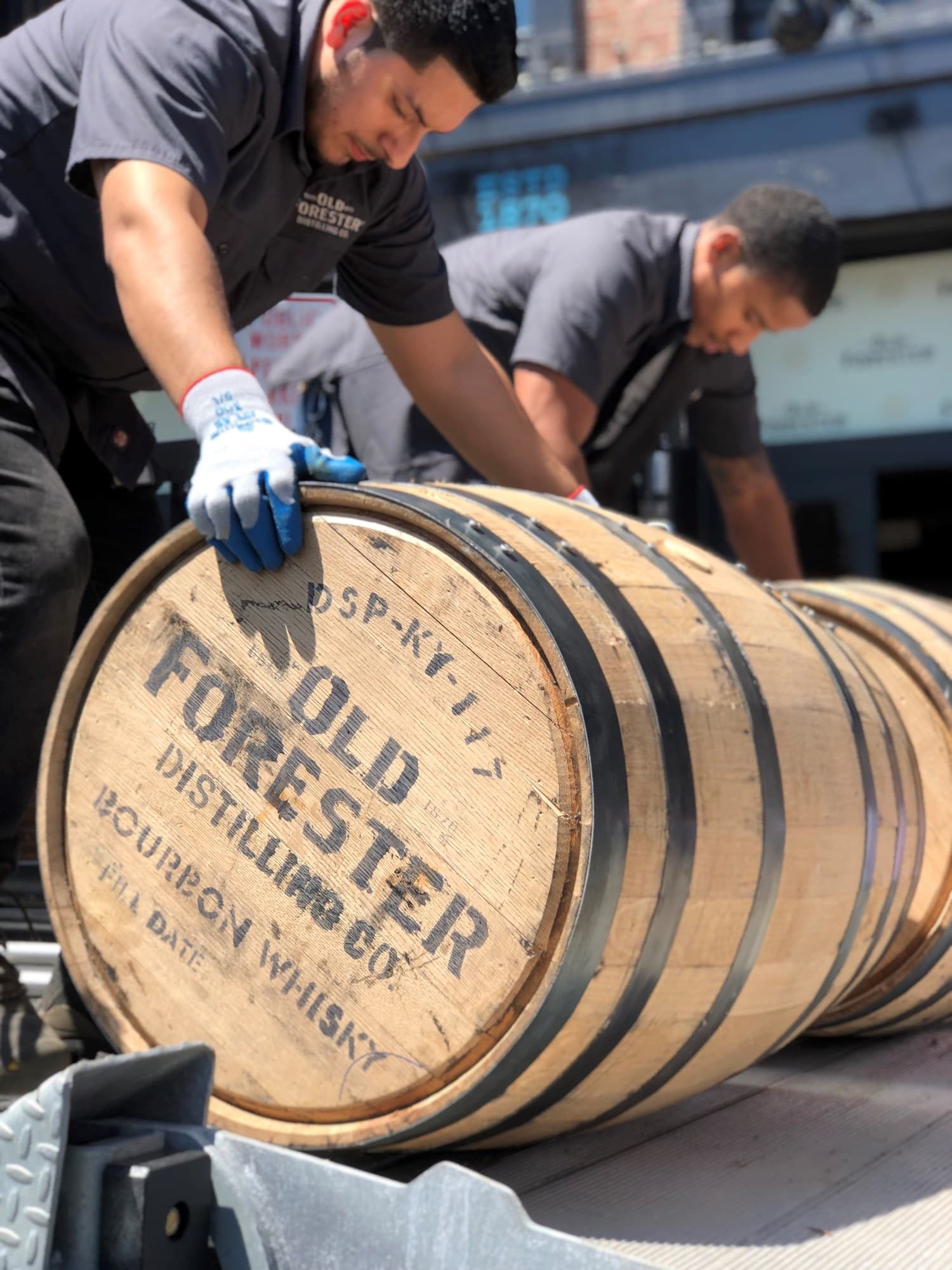 A cooper rolling a bourbon barrel at Old Forester Distilling Co.