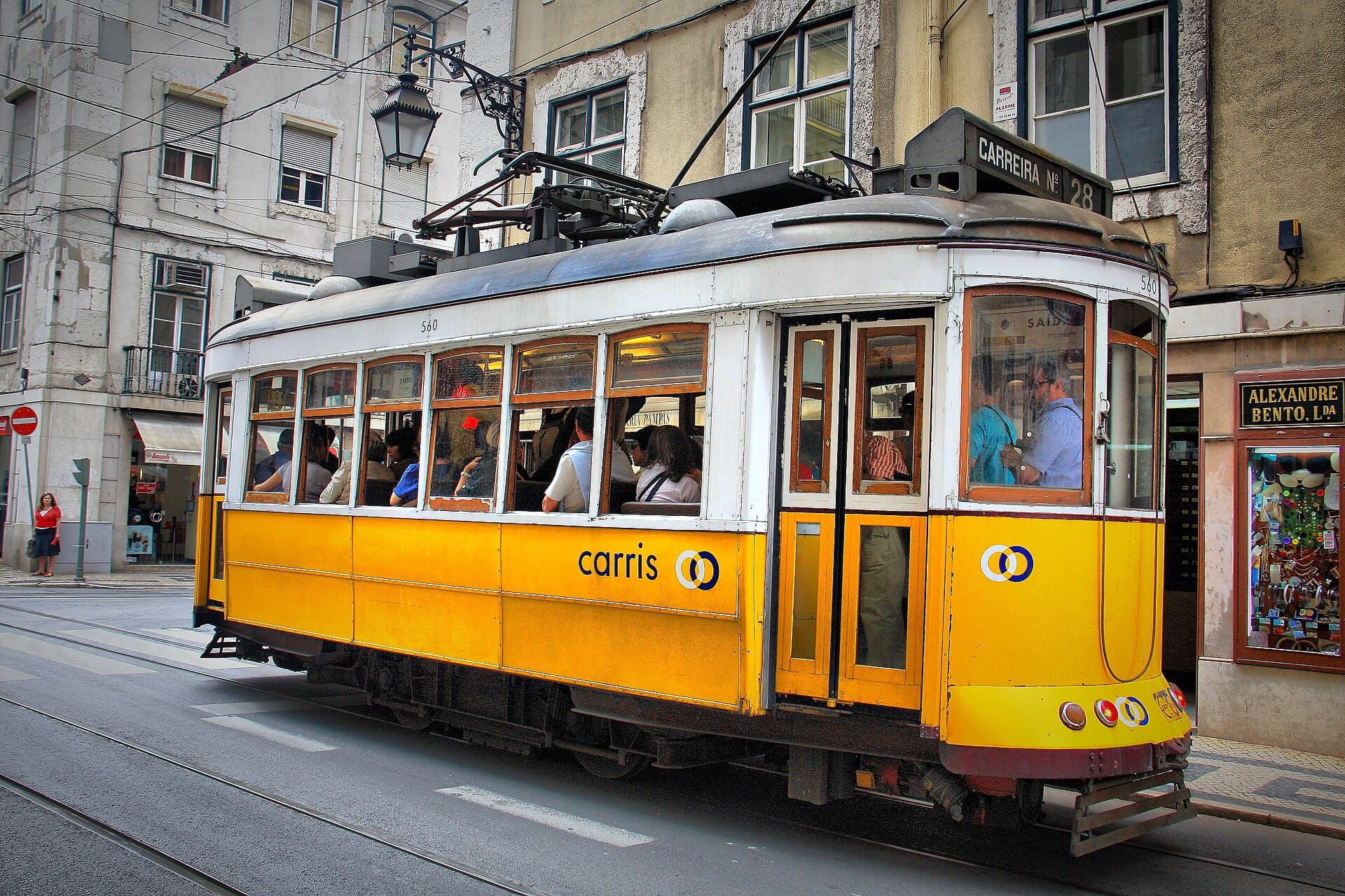 Historic yellow Tram 28 rolling through central Lisbon