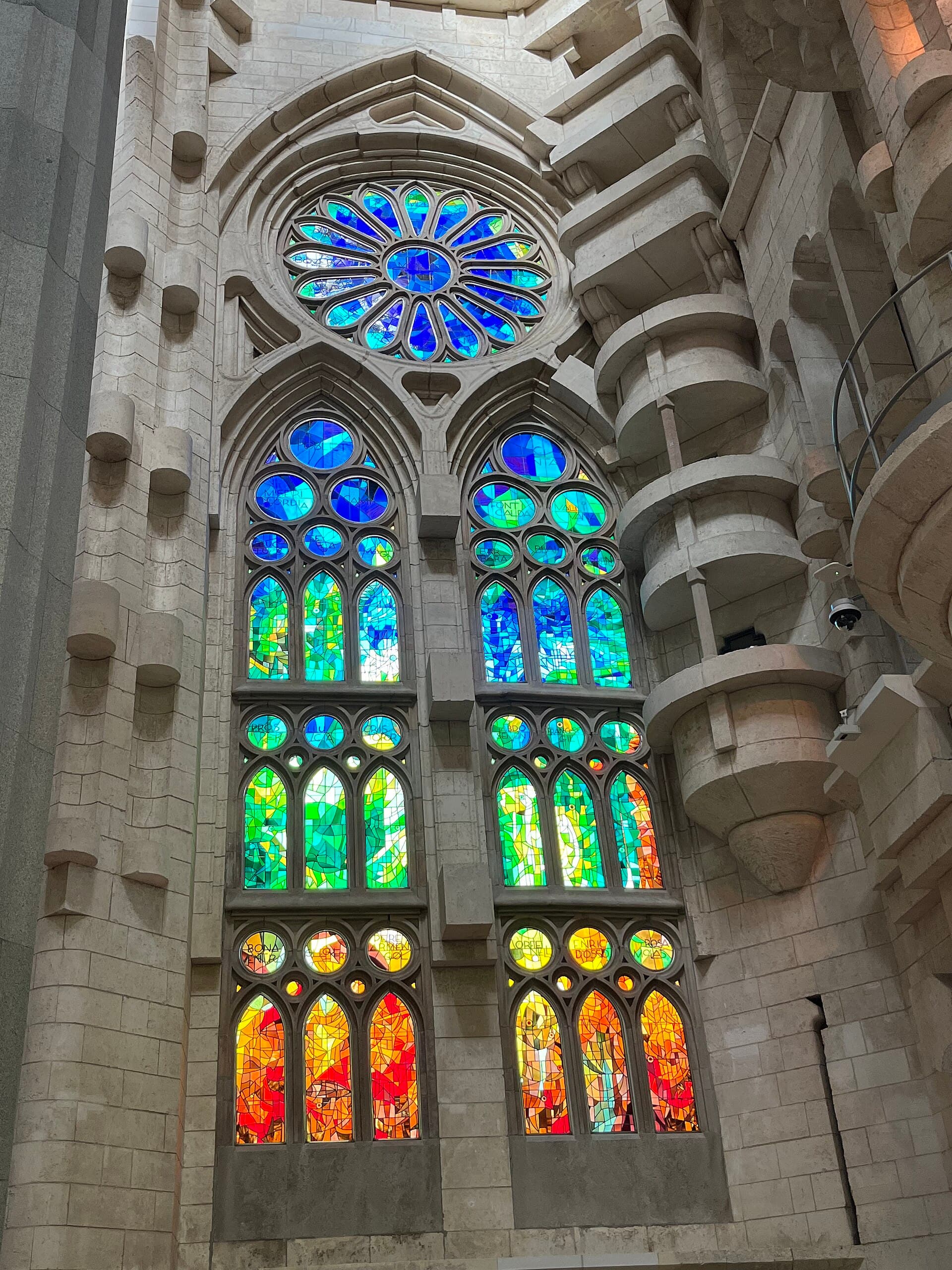 Colored stained-glass windows and branching stone columns inside the Sagrada Família