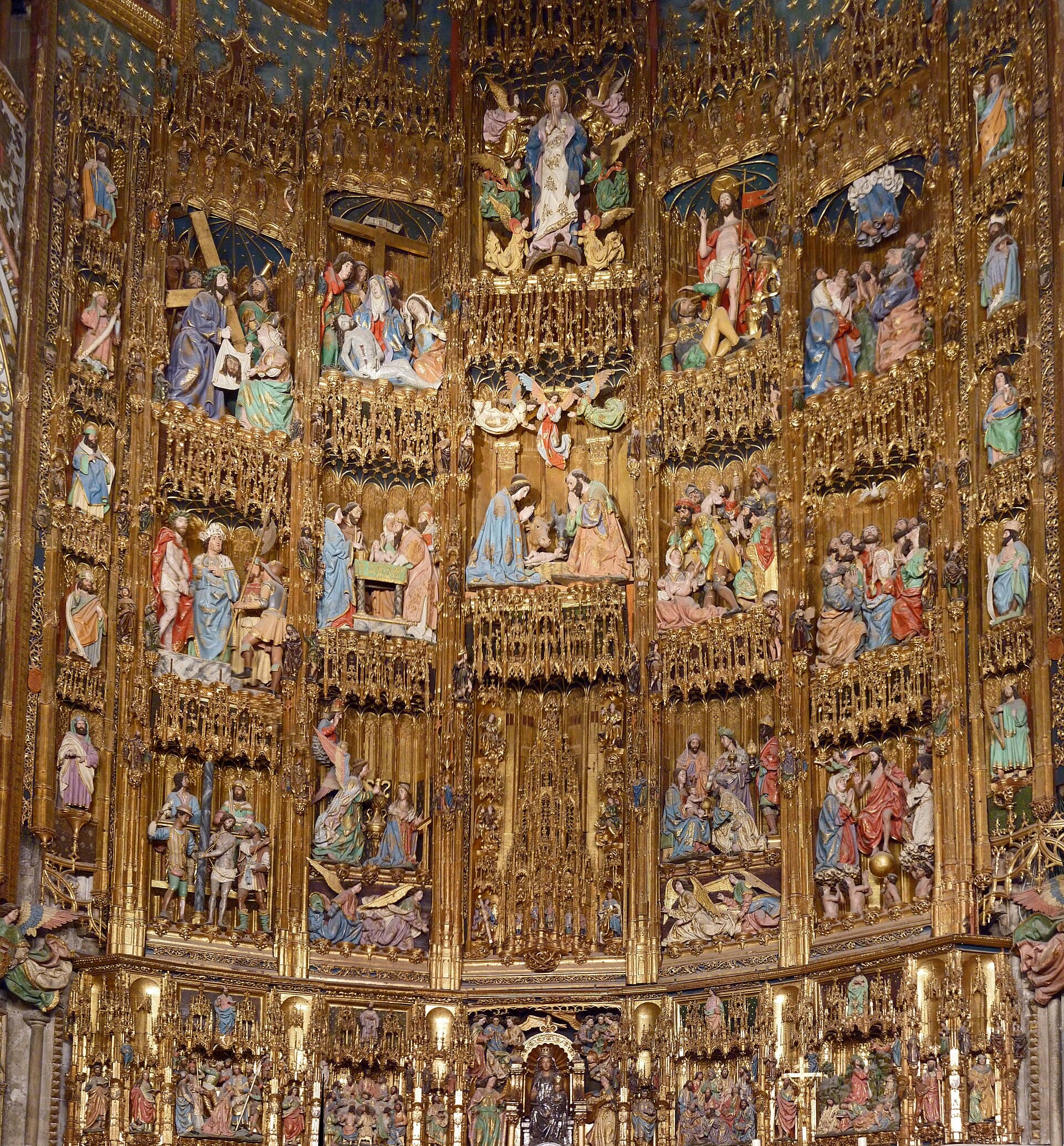 The monumental gilded high altar filled with painted sculptures inside Toledo Cathedral