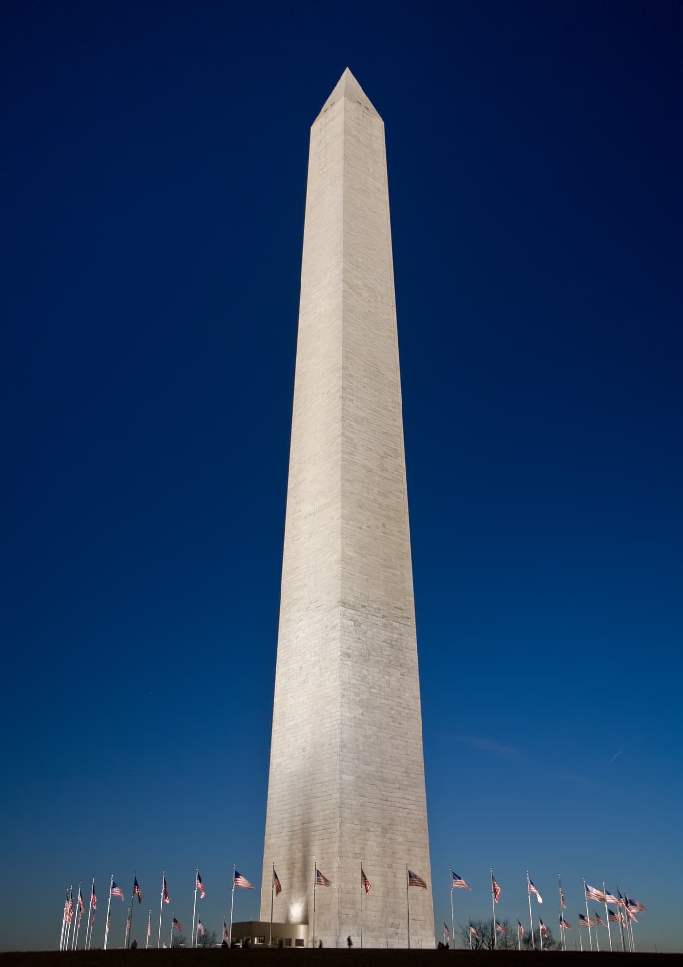 Washington Monument at dusk ringed by American flags